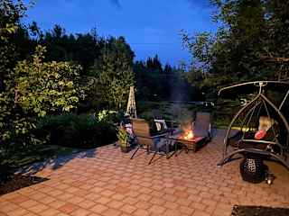 Front yard in the evening with our firepit and cozy swing