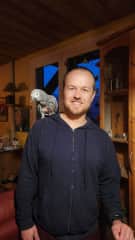 Chris with Paco, an African Grey Parrot who calls the French Alps home! Chris has extensive experience with birds.