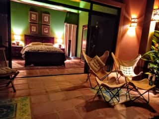 Looking into Master Bedroom from Terrace at Night.  Handmade terracotta wall sconces are on all exterior walls around the house.  Bed is Queen size.  All furniture Handmade by Local Artisans.