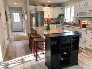 Kitchen and hall leading to office and downstairs bath, with side door to outside.