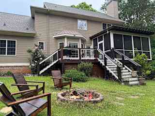 Backyard with fire pit. And deck. There is a green egg grill on the deck.