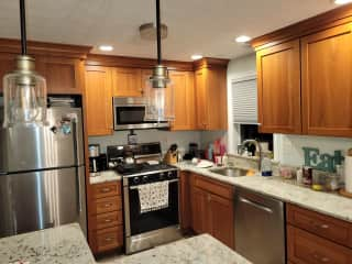 A 4 chair dining table is off kitchen in dining area.