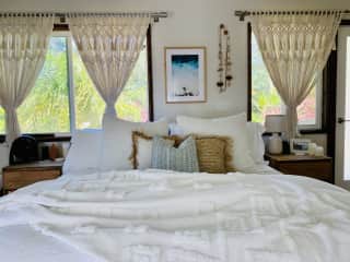 King bed in bedroom is divided from the living room with a sliding barn door.