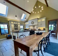 Communal Dining table and alternate view of kitchen and into sitting/living room @ far right doorway.