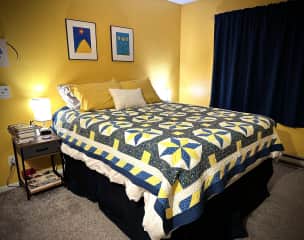 Main bedroom with queen bed. You'll sleep here if you're a couple. Note: heat in upstairs is turned off. This bed has a mattress heater. In summer, there is a portable air conditioner available for this room. Fans are also available.
