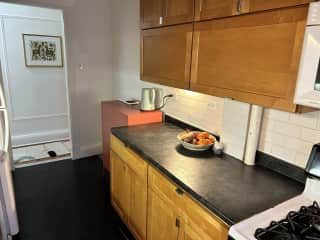 Microwave & oven (slightly out of view here), hot water kettle, and Uma's water & food bowl next to red cabinet on floor