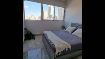 Bedroom with city view, queensize bed, AC and closet space.