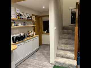 Staircase leading to upstairs rooms with passageway on the left leading to the bathroom.