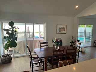 Open area dining and living room space with plenty of natural sunlight.