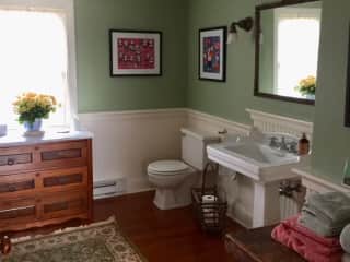 Upstairs guest bathroom with pedestal sink, shower, original clawfoot bathtub