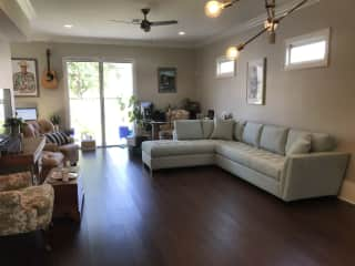 Living room with TV and new couch. Still rearranging things a bit in this room. Under the guitar is a desk with wifi and a printer. The screen doors to the back deck are also pictured.