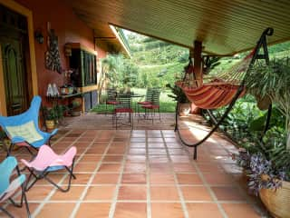 Front porch viewed from driveway featuring seating and dining areas.  And what would a stay in Costa Rica be without a hammock?