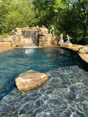 Backyard pool and waterfall w/ beach entry, 3ft zone, and 9ft depth zone under waterfall