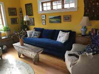 Living room with velvet couch and antiques. 
Wood floors throughout house