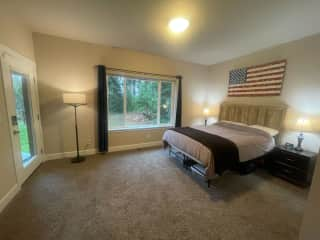 Guest bedroom featuring its own entrance onto the back patio, overlooking a rain garden. Also has an en-suite private bathroom.