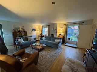 Sitting room with bifold doors to garden and outside seated area. Large smart TV