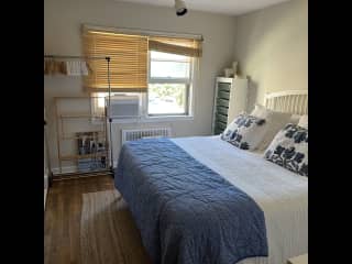 Guest bedroom with a window air conditioner for the summer, and central heating for the winter. Also includes hanging space, and many drawers.