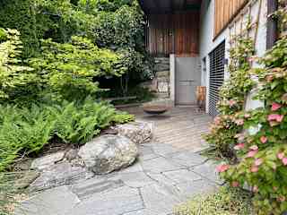 lower west terrace outside sauna, with outside shower, fire pit, and seating area