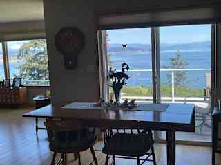 Dining area with deck and outdoor eating area. Small barbecue on deck. Large barbecue on patio below.