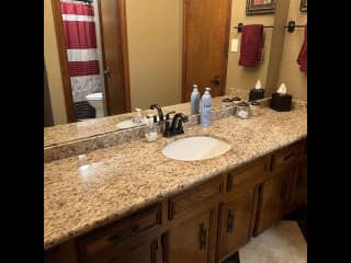 Bathroom for guest use.  Large counter top area with another area with bathtub/shower combination.
