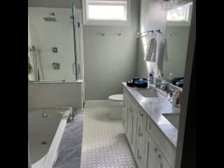 En suite master bathroom. Dual sinks, spa tub, and shower.