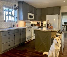 Spacious modern kitchen with granite countertops, as well as an island with bar stools.