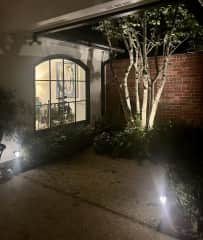 Landscaped front entry courtyard with wall fountain, patio, ceiling fans and lighting.