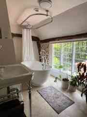 The bathroom with bath and shower.
