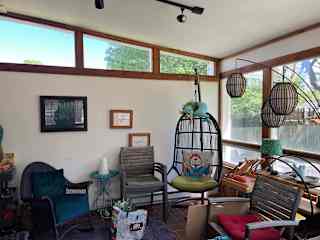 a sunroom with a very comfy hanging chair  - and lots of arts material (which we'll gladly clear away for you - all art materials live in the basement).