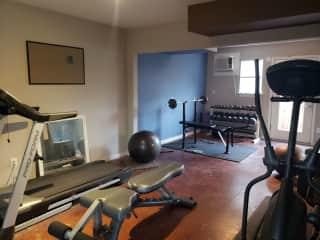 The modest workout room includes a treadmill,  elliptical, weights and benches.