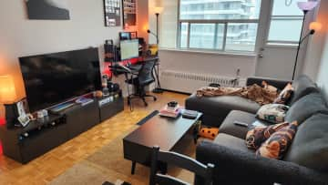 Living room. Sofa, TV, Desk. Balcony outside.