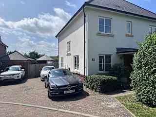Front of the house and private driveway for parking.