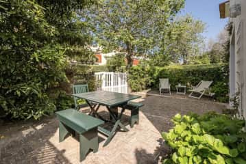 Sweet garden with picnic table and garden chairs.