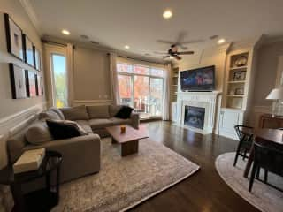 Cozy living room with fireplace, tv, couch and kitchen table