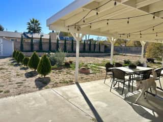 Large backyard space with outdoor dining area, covered patio, fire pit and grill.