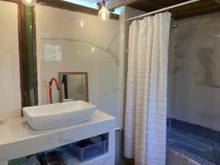 Downstairs bathroom with hot water shower.