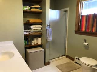 The bathroom is next to the guestroom. It includes a stacked washer/dryer, not pictured.