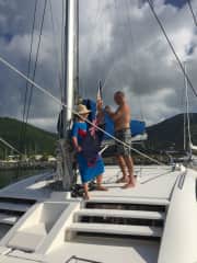 Julia and Stuart preparing to hoist the Union Jack on their catamaran.