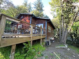Back deck with pellet grill, outdoor dining table and chairs.