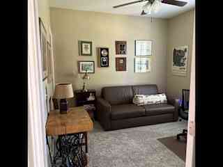 Office with fold out sofa, desk (not visible here), computer on desk, and walk-n closet left of the sofa.
