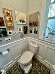 “Water closet”. This room only has a toilet and an eclectic art gallery.