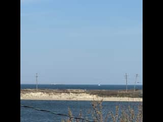 View from deck off primary bedroom: Shrewsbury River, Sandy Hook National Park and Atlantic Ocean.