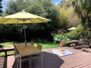 Sunny back deck with seating and shade.