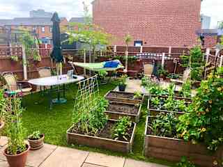 The back garden in early summer. To create more space, you can move the table and umbrella onto the stone patio at the back of the garden and put the hammock away in the garden shed.
