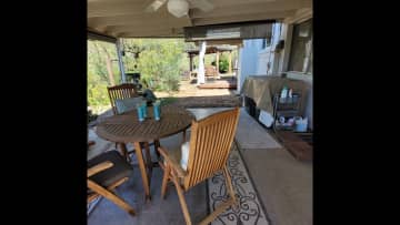 Washer dryer plus clothes line are outdoors under patio roof.