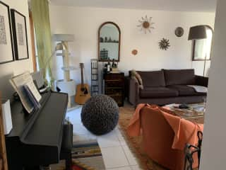 Living room with a piano and a guitar.