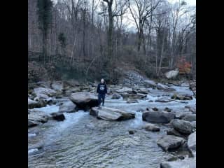 My brother-in-law standing on the large boulders  in the river in front of our house.