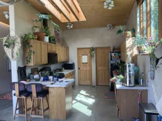 Kitchen, view from walking inside front door. All the cooking supplies you could need; help yourself! Most of my plants are in here. Back right door is laundry room, along with cleaning supplies.