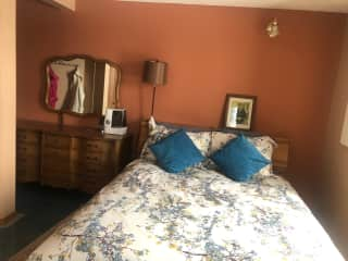 Large guest room with a dresser with empty drawers.