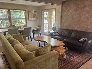 Cozy living room and dining area: two couches, gorgeous area rug, maple slab coffee table and throw blankets. French doors open to the deck outside for patio seating, grilling, etc.